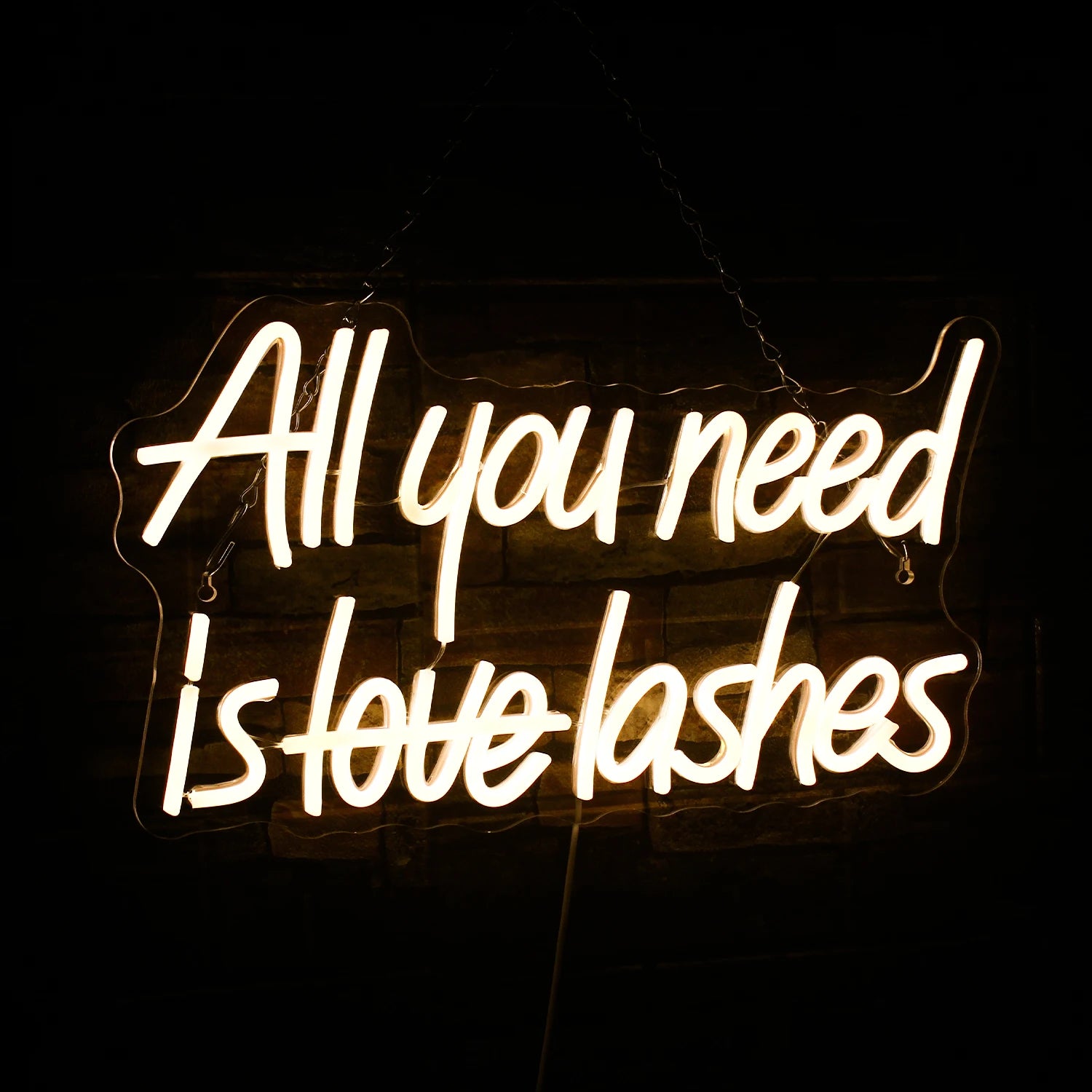Das Bild zeigt ein leuchtendes LED-Neonschild mit dem Satz „All You Need is Lashes“ in eleganter Schreibschrift.