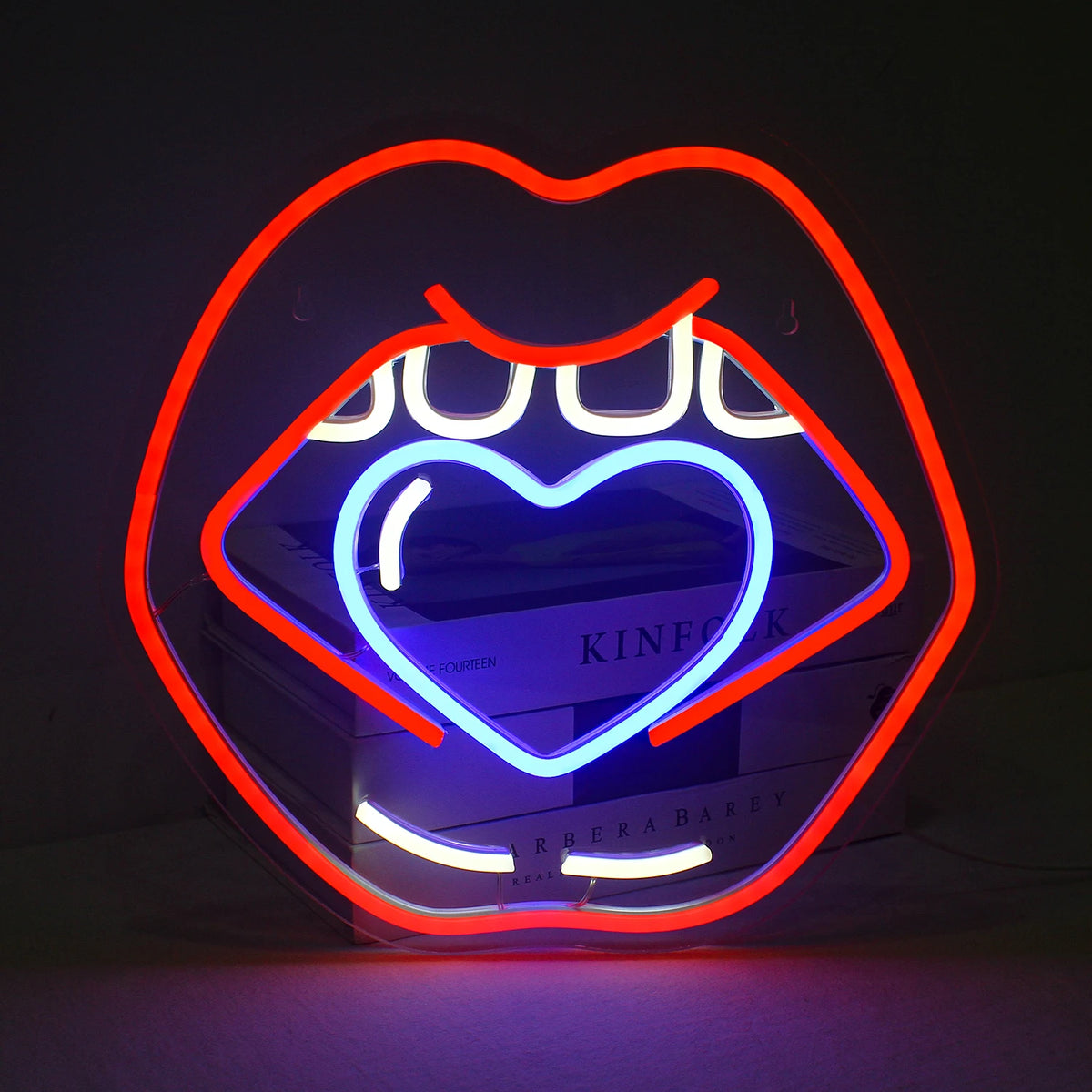 „Caring Lips LED-Neonschild – Ein preisgünstiges Schild mit der Umrisszeichnung voller, geschürzter Lippen in leuchtenden Rosatönen.