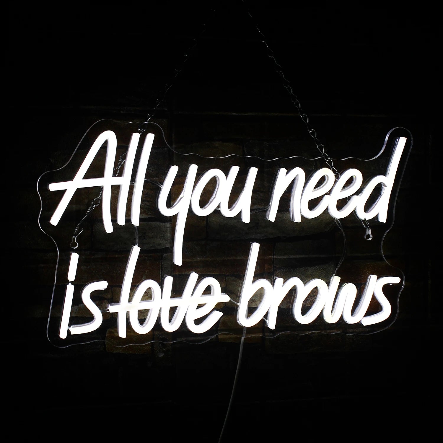 Das Bild zeigt ein leuchtendes LED-Neonschild mit der Aufschrift „All you need is brows“.