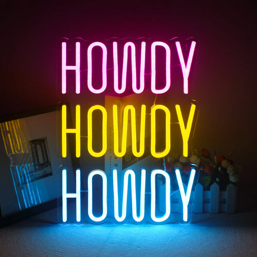 Ein lebendiges, handgefertigtes LED-Neonschild mit dem Wort „Howdy“ in einer verspielten, kursiven Schriftart.