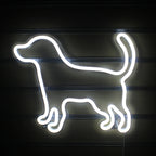 Ein leuchtendes LED-Neonschild in Form eines kleinen, verspielten Hundes.