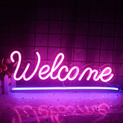 Ein leuchtendes LED-Neonschild mit der Aufschrift „Willkommen“ vor einer schlichten weißen Wand.