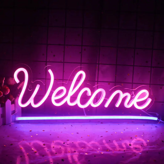 Ein leuchtendes LED-Neonschild mit der Aufschrift „Willkommen“ vor einer schlichten weißen Wand.