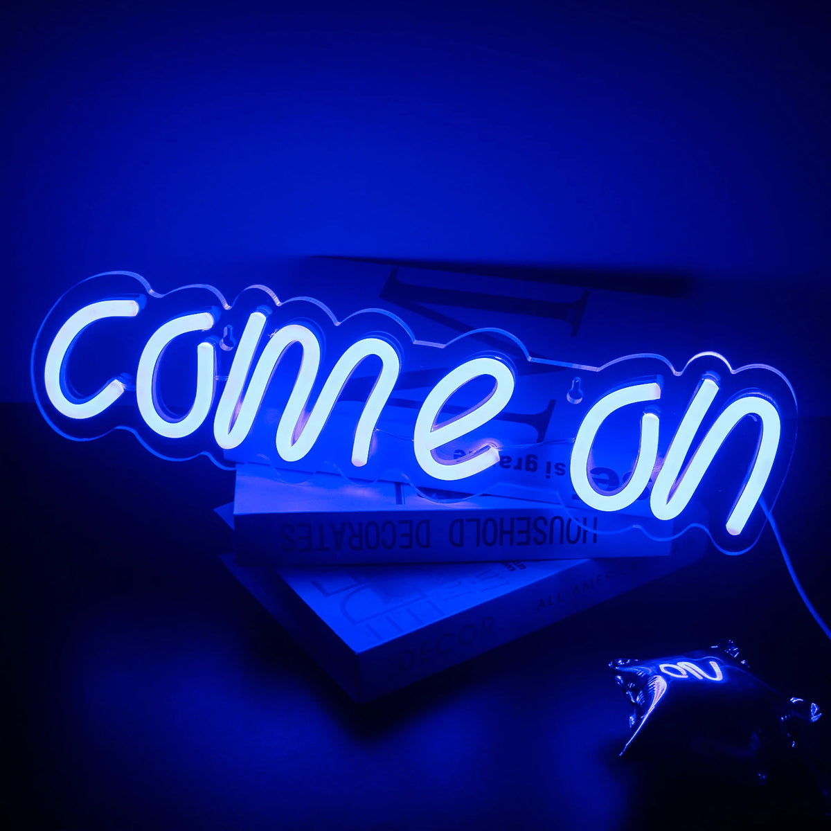 Das Bild zeigt ein leuchtendes LED-Neonschild mit den Worten „Come On“ in einer kräftigen und verspielten Schreibschrift.
