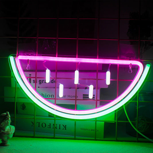 A vibrant LED neon sign shaped like a watermelon slice, featuring bright pink and green colors.