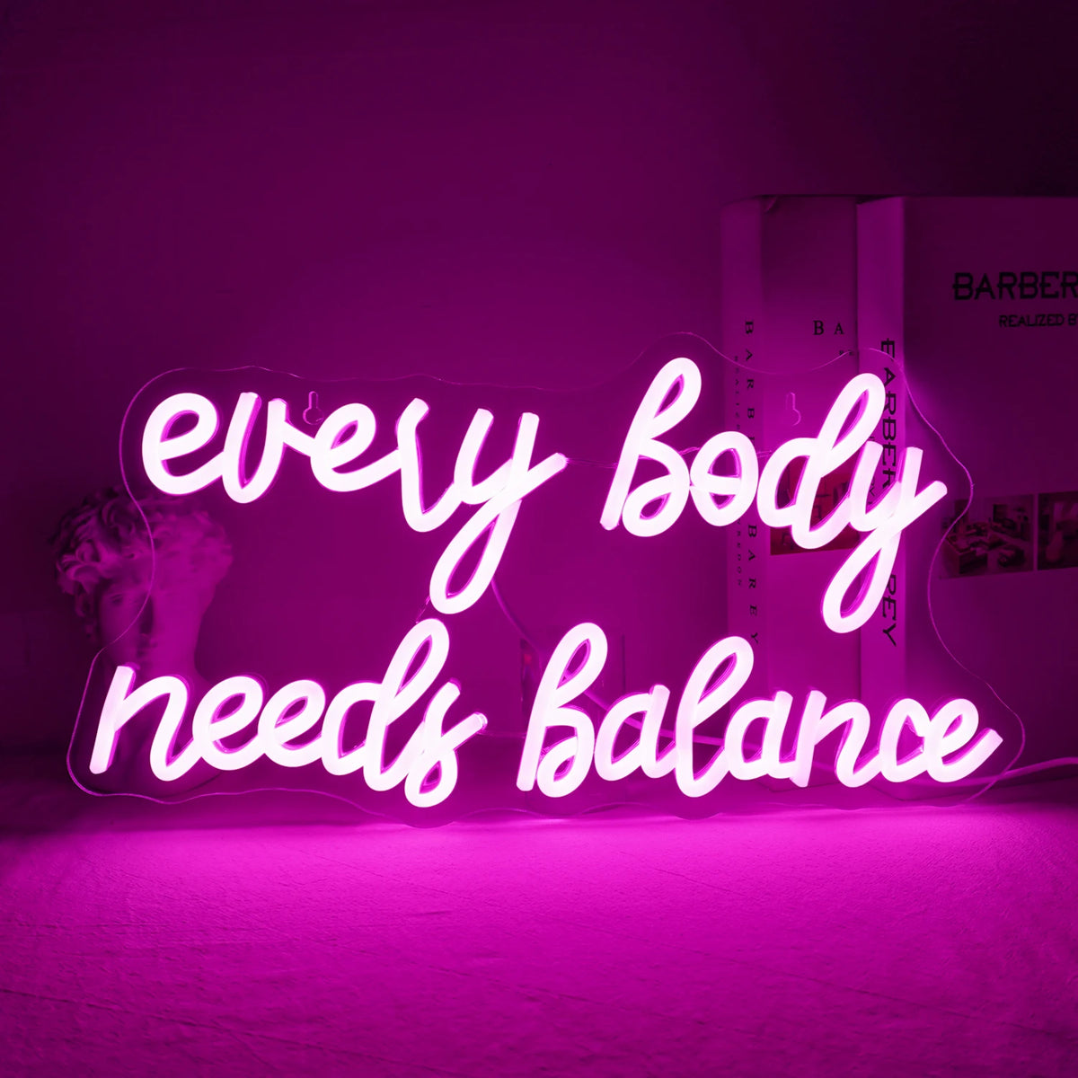 Das Bild zeigt ein leuchtendes LED-Neonschild mit der Aufschrift „Every Body Needs Balance“.