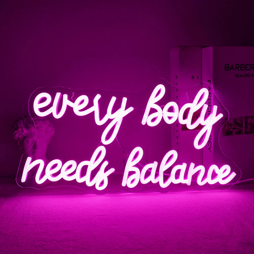 Das Bild zeigt ein leuchtendes LED-Neonschild mit der Aufschrift „Every Body Needs Balance“.