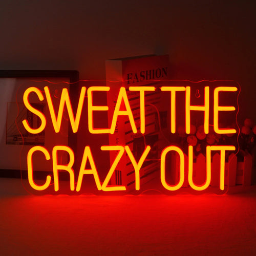 Ein leuchtendes LED-Neonschild mit dem Satz „Sweat The Crazy Out“ in einer verspielten Schreibschrift.