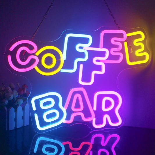 A vibrant LED neon sign displaying the words "Coffee Bar" in a warm, yellow hue.