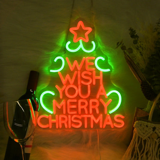 The image features a vibrant LED neon sign displaying the words "We Wish You A Merry Christmas" in a festive, cursive font.