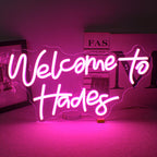 Ein LED-Neonschild mit den Worten „Willkommen im Hades“ in hell leuchtenden Neonlichtern.