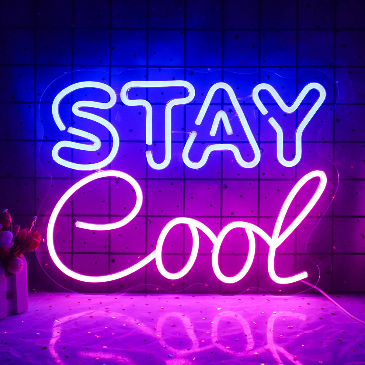 A vibrant "Stay Cool" LED neon sign is displayed, featuring bold, cursive lettering.