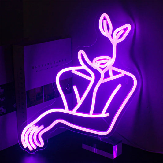 The image features a stylish LED neon sign depicting minimalist line art of a woman's face.