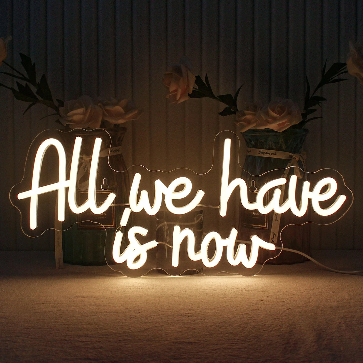 Das Bild zeigt ein handgefertigtes LED-Neonschild mit den Worten „All We Have Is Now“ in leuchtenden Buchstaben.