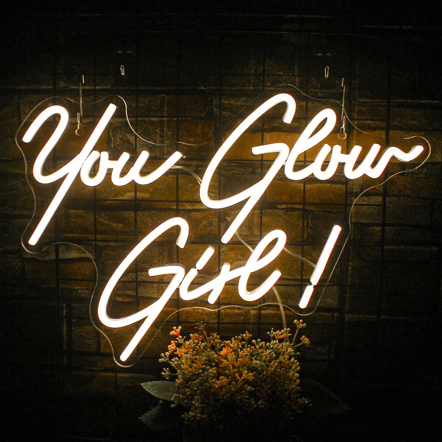 The image features a vibrant "You Glow Girl" LED neon sign.