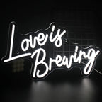 A vibrant LED neon sign displaying the phrase "Love is Breaking," featuring bold, modern typography.