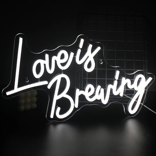 Ein leuchtendes LED-Neonschild mit dem Satz „Love is Breaking“ und kräftiger, moderner Typografie.