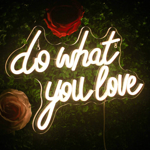 Das Bild zeigt ein leuchtendes LED-Neonschild mit dem motivierenden Satz „Tu, was du liebst“ in fetter, kursiver Schrift.