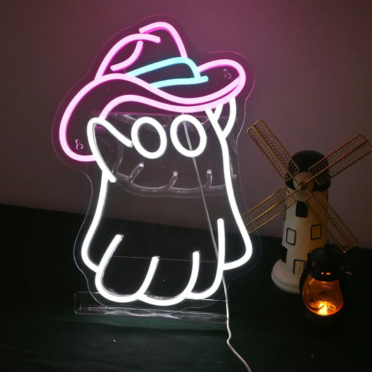 The image displays a vibrant LED neon sign in the shape of a playful ghost wearing a cowboy hat.