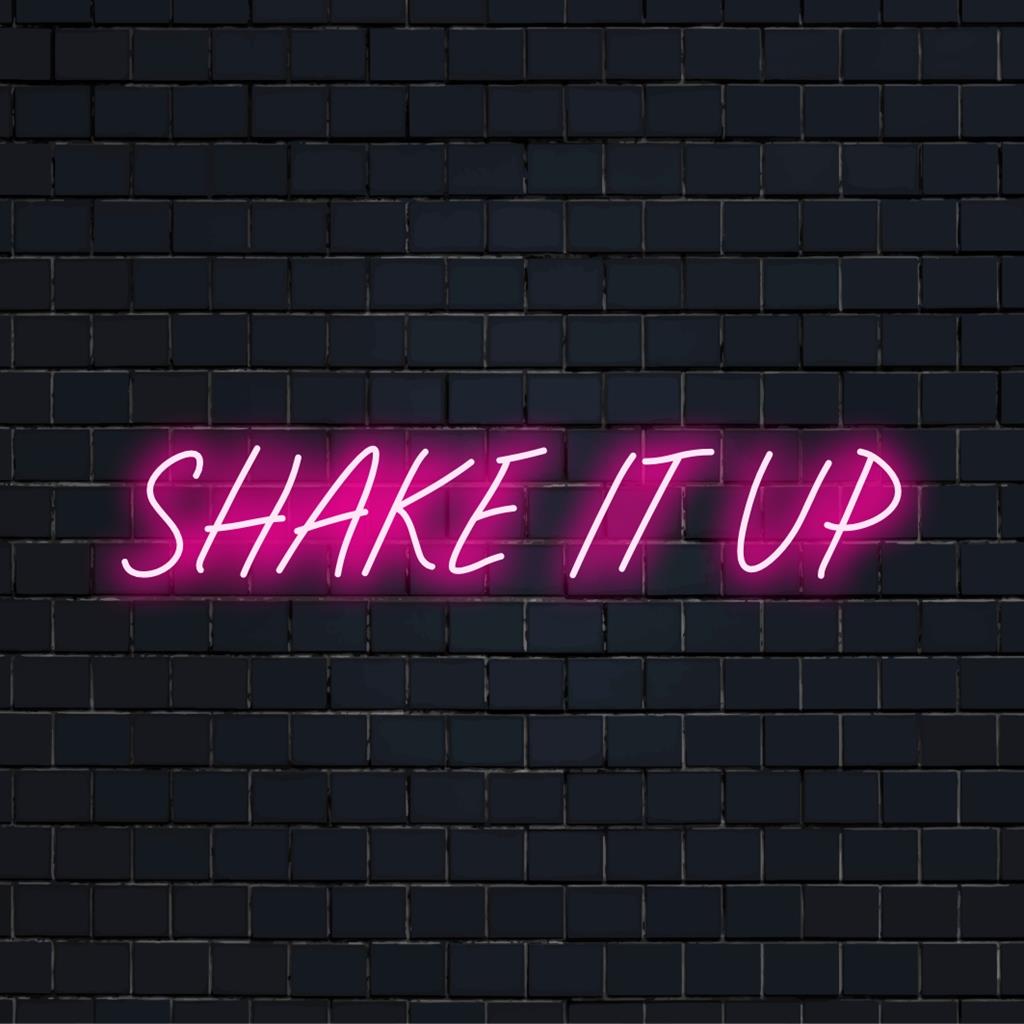 Energiegeladenes orange-pinkes LED-Neonschild mit der Aufschrift „Shake It Up“, das pulsierende Energie und Partystimmung verkörpert.