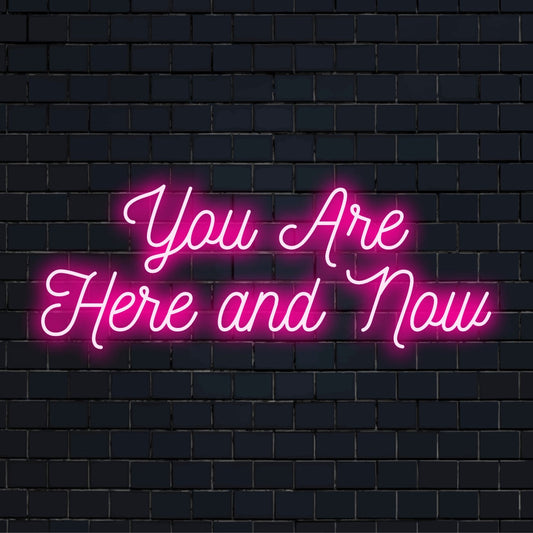 Custom-made LED neon sign saying You Are Here and Now with cool light radiance, suitable for any modern space.