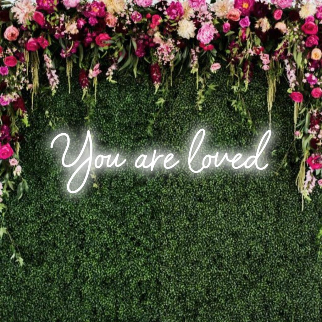 A vibrant custom LED neon sign with the message You Are Loved illuminating spaces with warmth and encouragement.