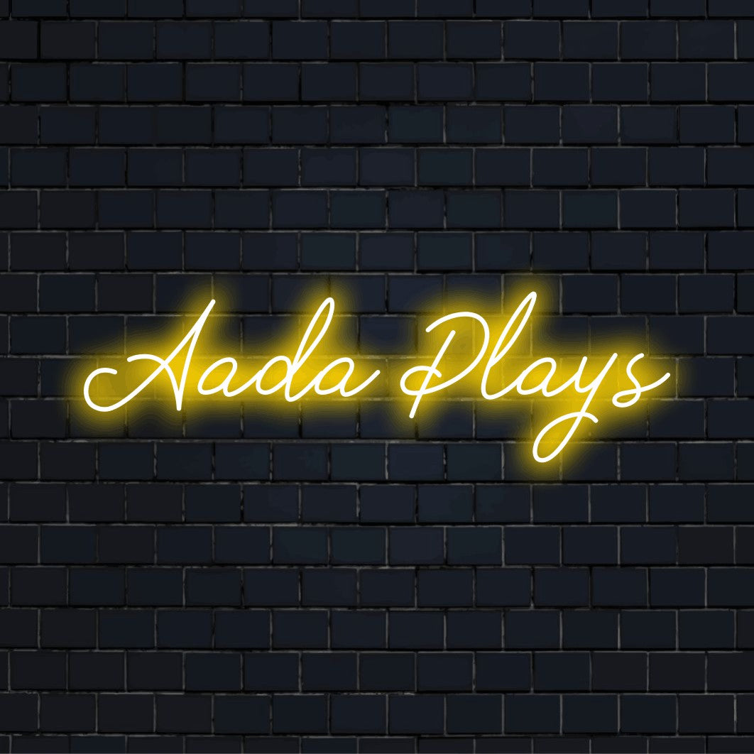 Aada Plays Personalized Neon Light with glowing wall decor on dark brick wall