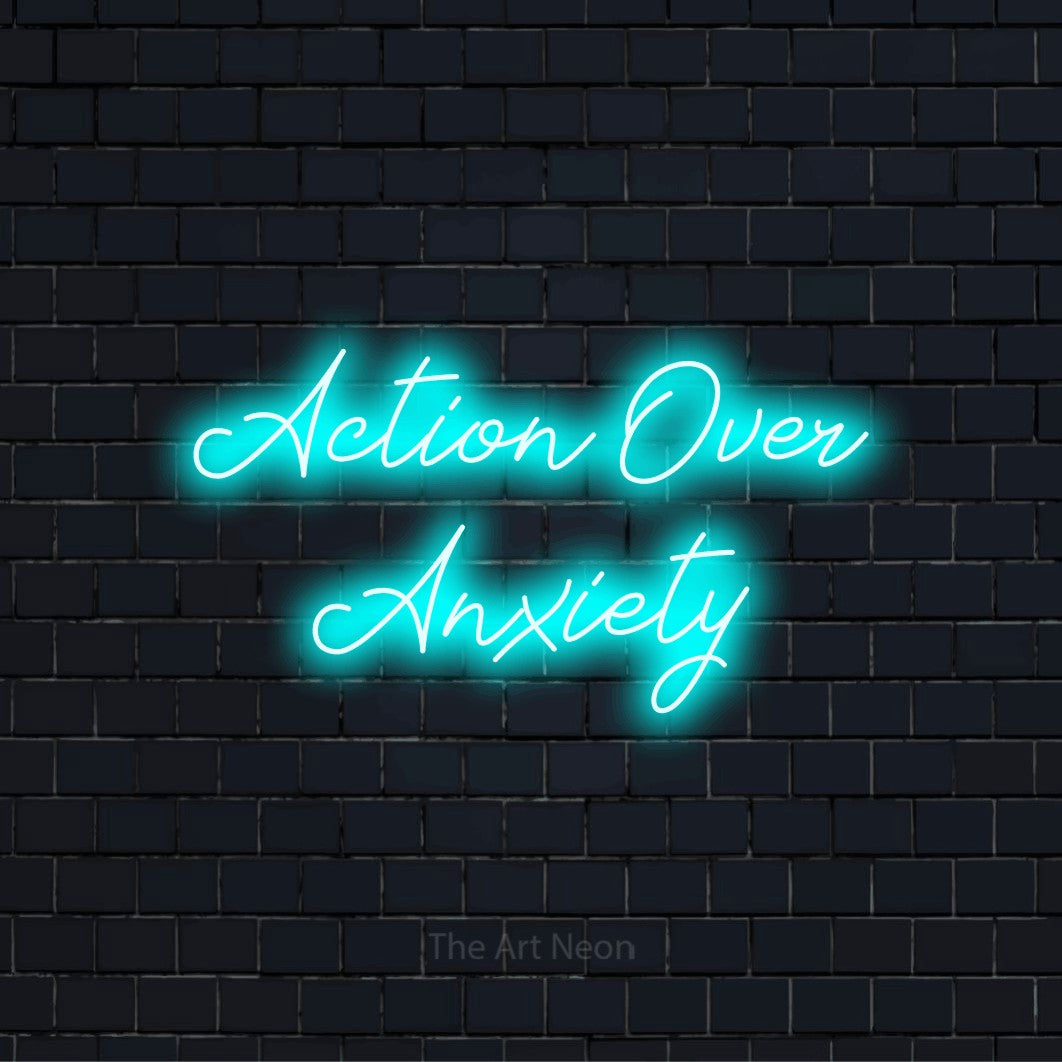 "Action Over Anxiety" LED neon sign on a black brick wall