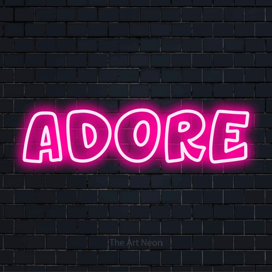 "Adore" neon text design on a black brick wall