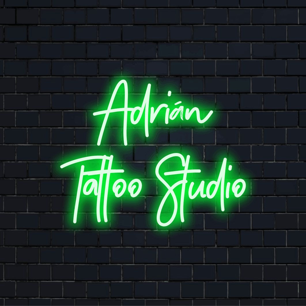 Adrian Tattoo Studio Custom Name Neon Sign, glowing neon text on black brick background