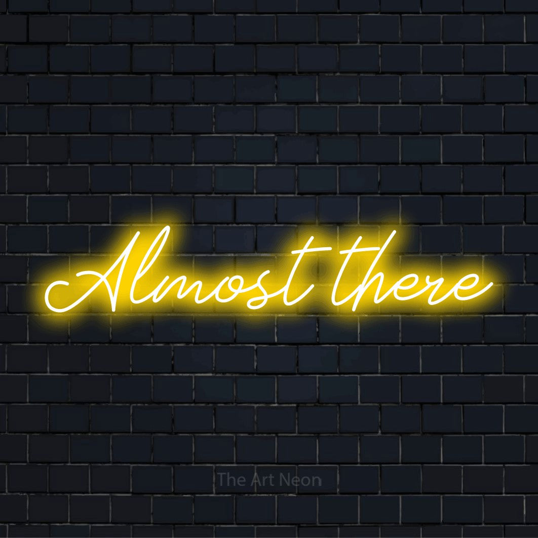 "Almost There" neon text design on a black brick wall