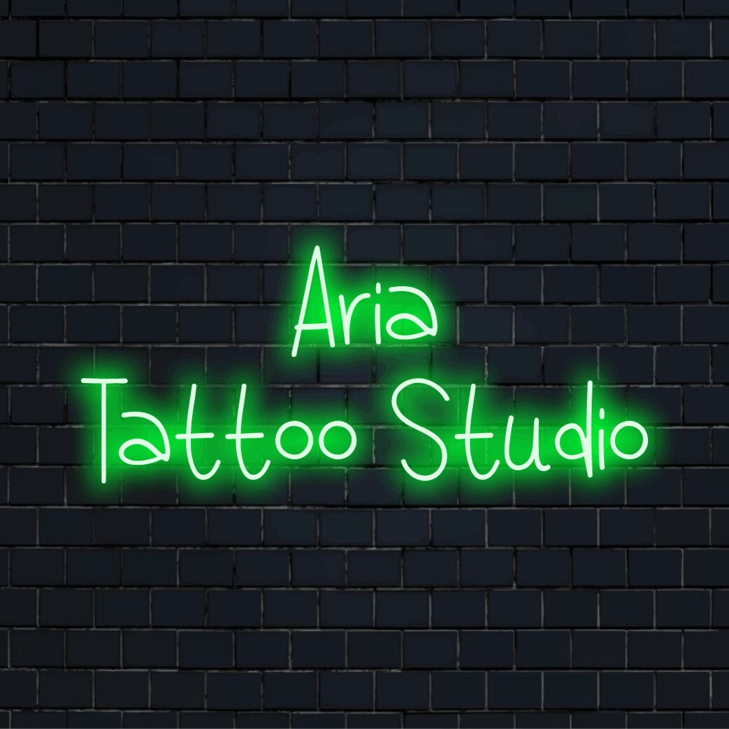 Aria Tattoo Studio Personalized Neon Light with glowing neon text against brick backdrop