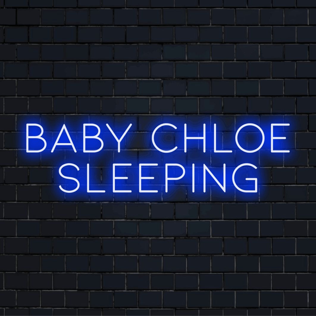 Baby Chloe Sleeping Personalized LED Neon Sign, bright neon lettering against black brick wall