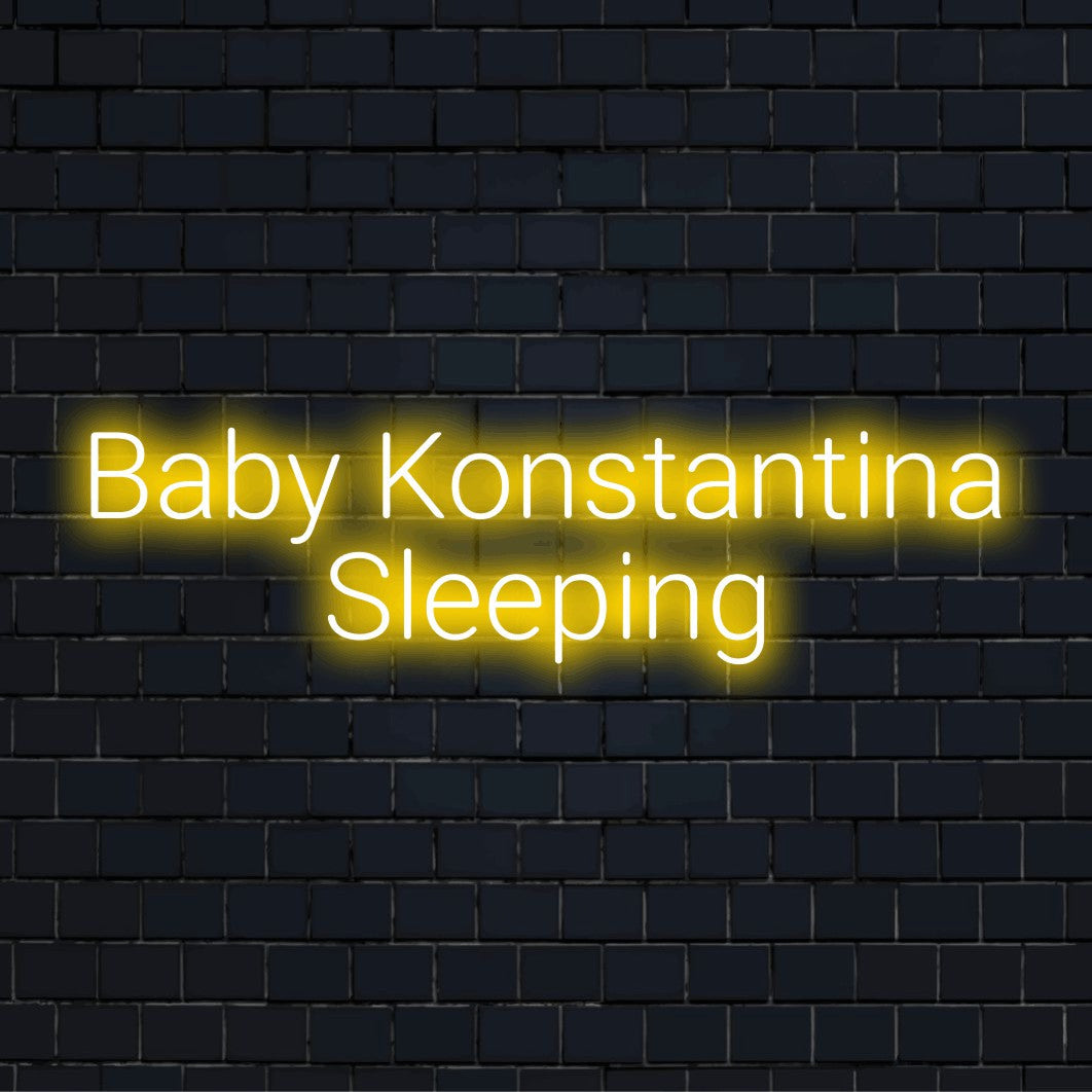 Baby Konstantina Sleeping Personalized LED Neon Sign, bright neon lettering on dark brick wall