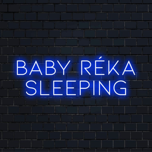 Baby Reka Sleeping Personalized Neon Light with bright neon glow against brick backdrop