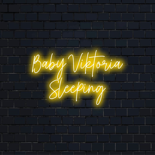 Baby Viktoria Sleeping Custom Name Neon Sign, glowing wall decor against brick backdrop
