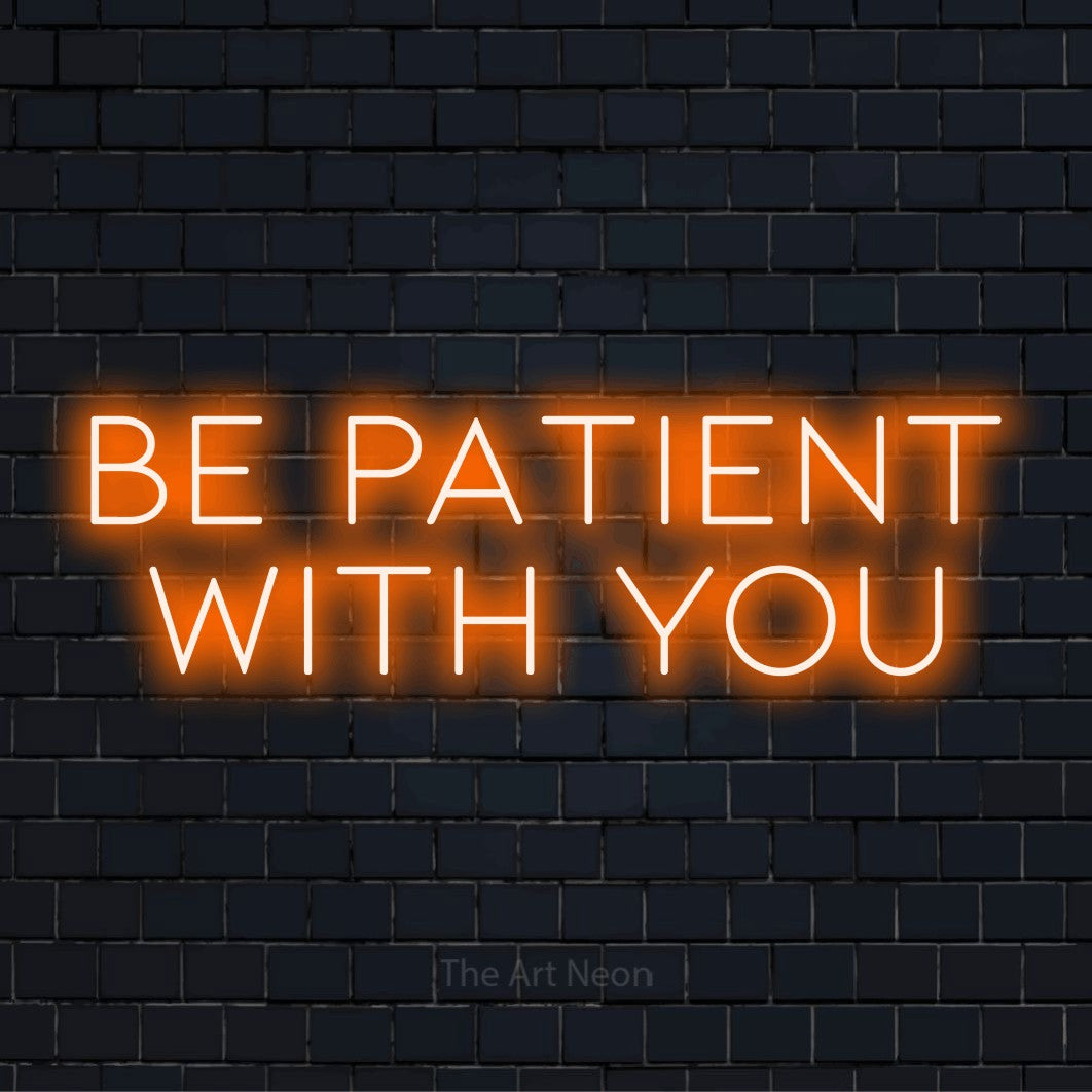 "Be Patient With You" neon text design on a black brick wall