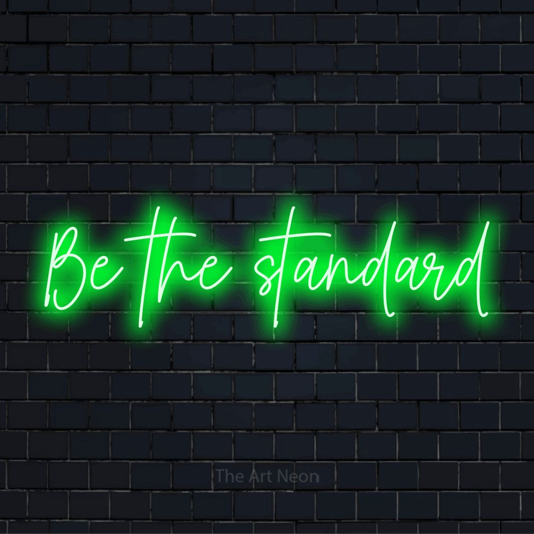 "Be The Standard" glowing LED neon sign on a black brick wall