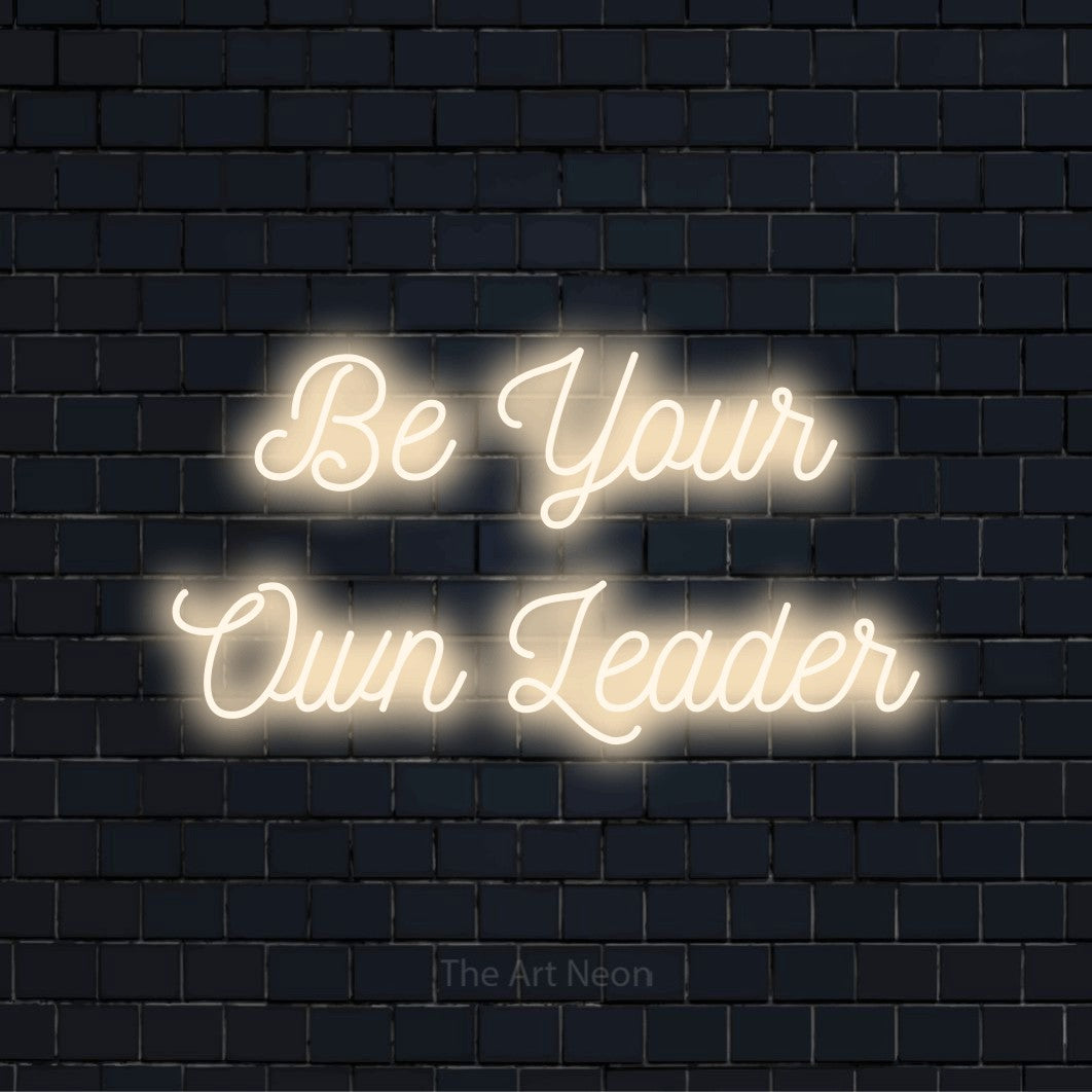 "Be Your Own Leader" glowing LED neon sign on a black brick wall