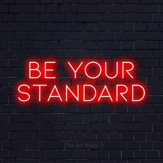 "Be Your Standard" neon text design on a black brick wall