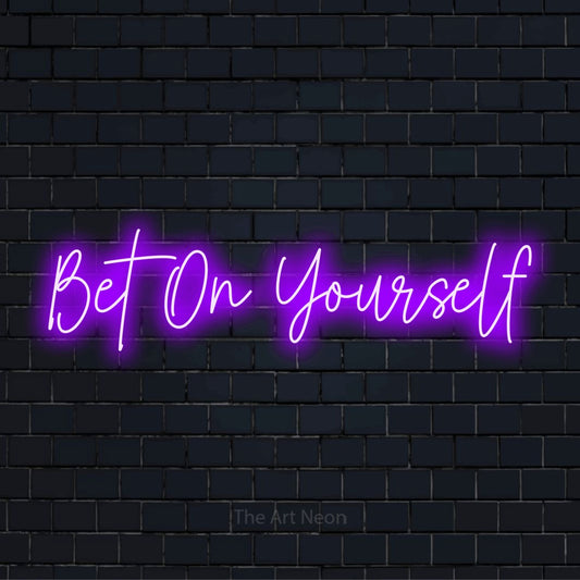 "Bet On Yourself" glowing LED neon sign on a black brick wall
