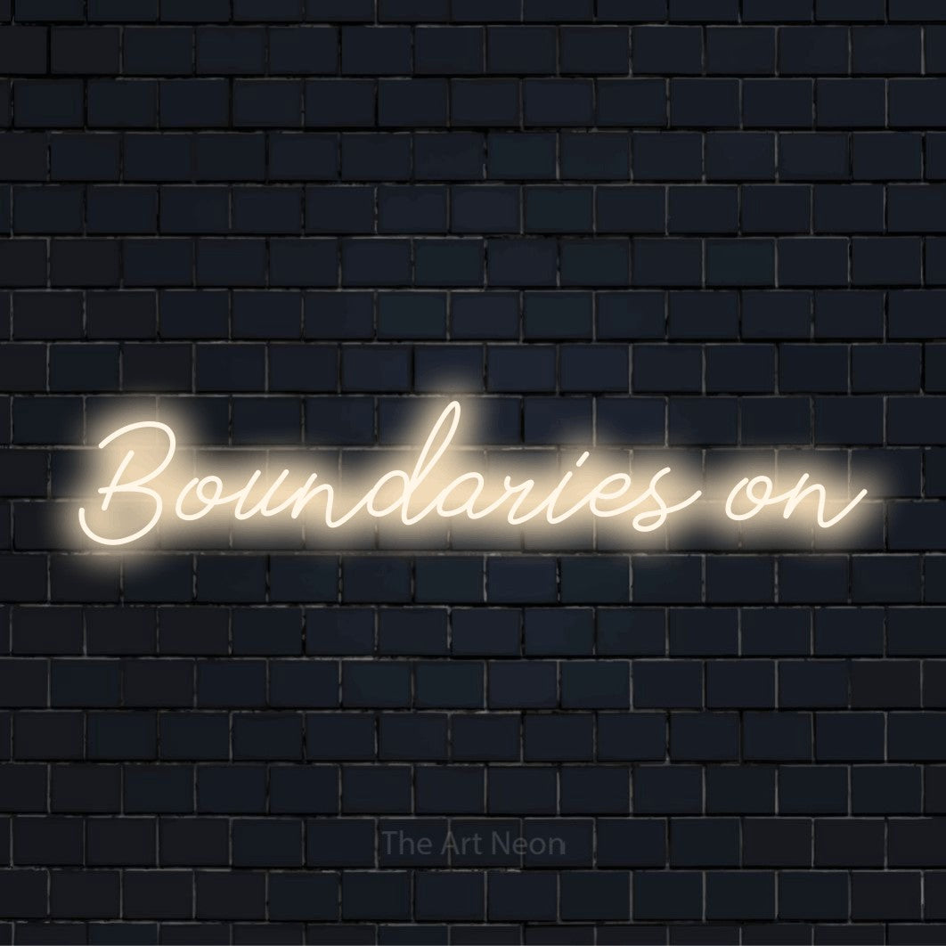 "Boundaries On" neon text design on a black brick wall