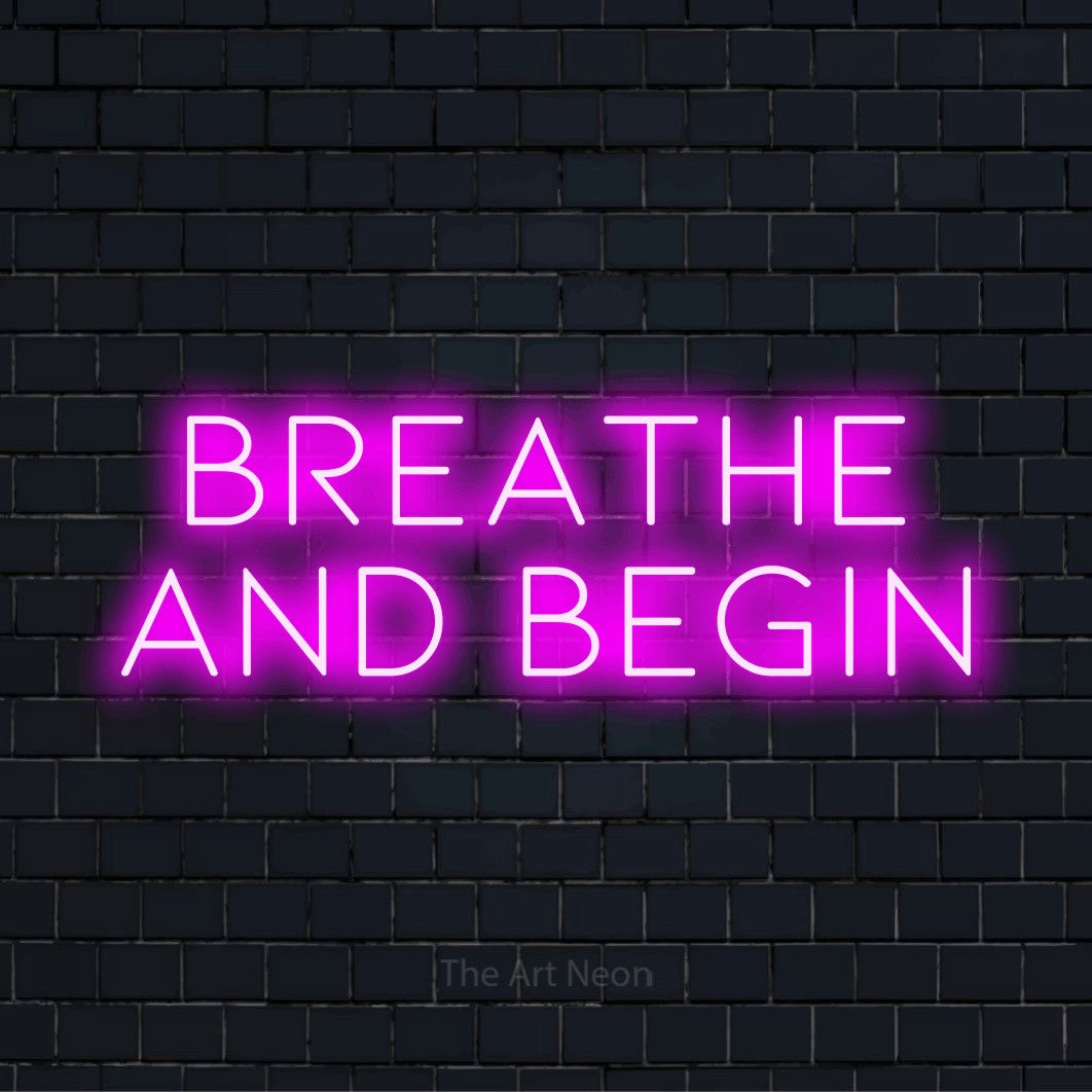 "Breathe And Begin" neon text design on a black brick wall