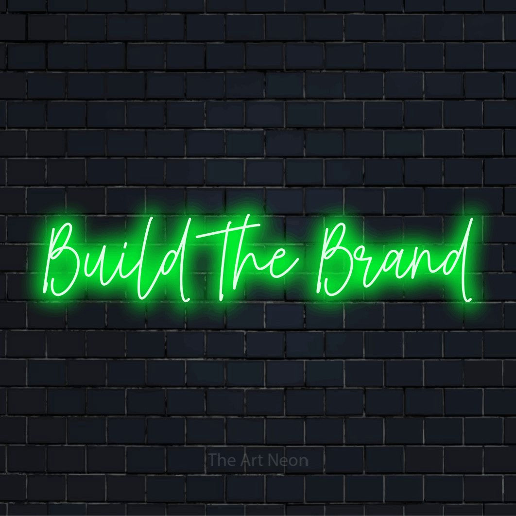 "Build The Brand" LED neon sign on a black brick wall