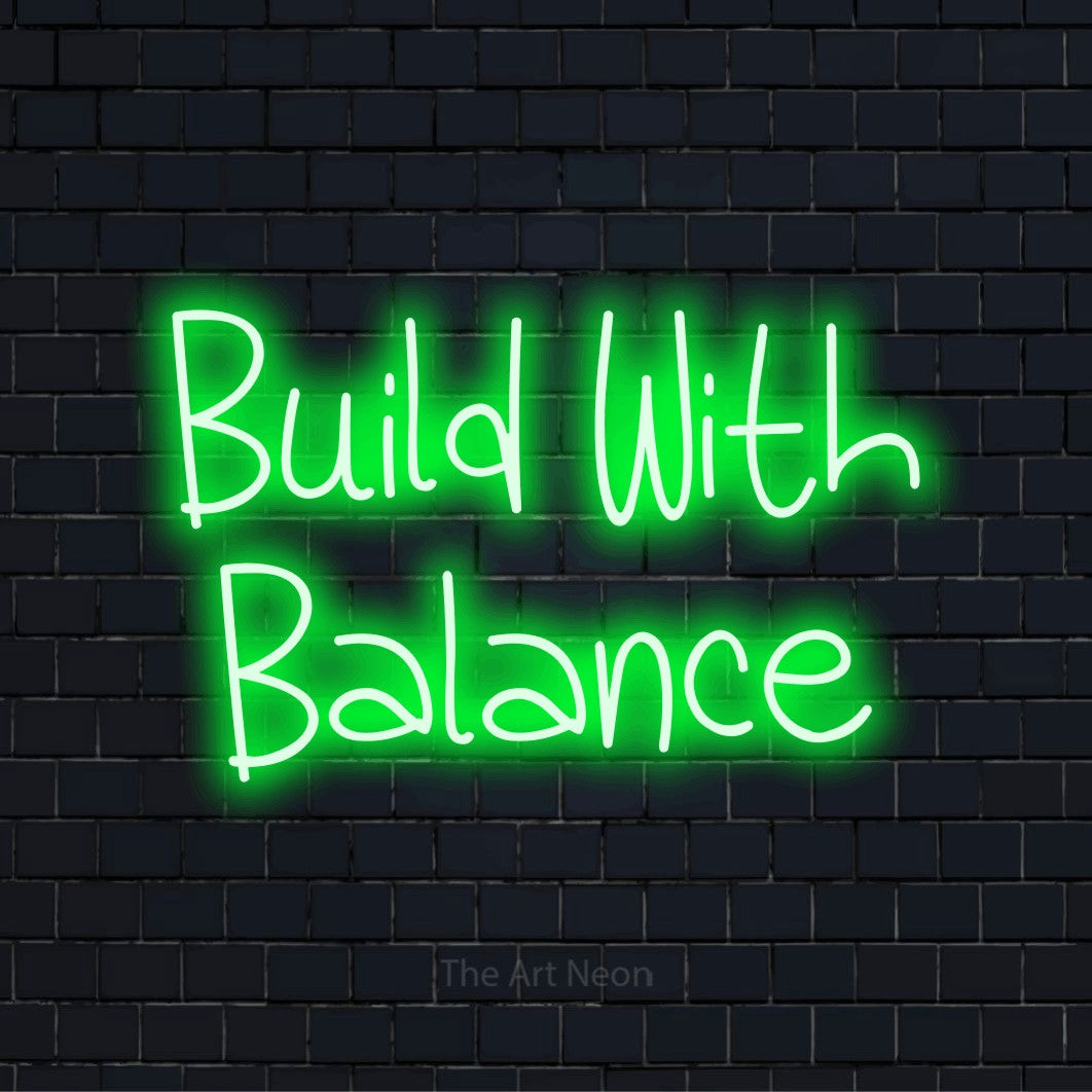 "Build With Balance" neon text design on a black brick wall