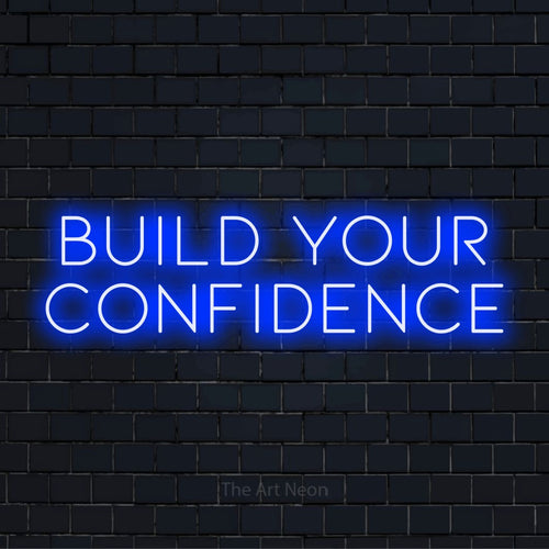 "Build Your Confidence" LED neon sign on a black brick wall