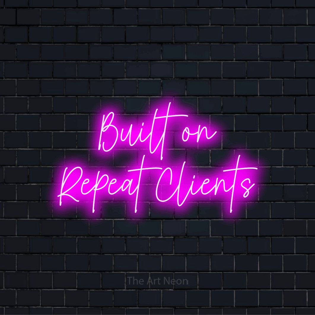 "Built On Repeat Clients" glowing LED neon sign on a black brick wall