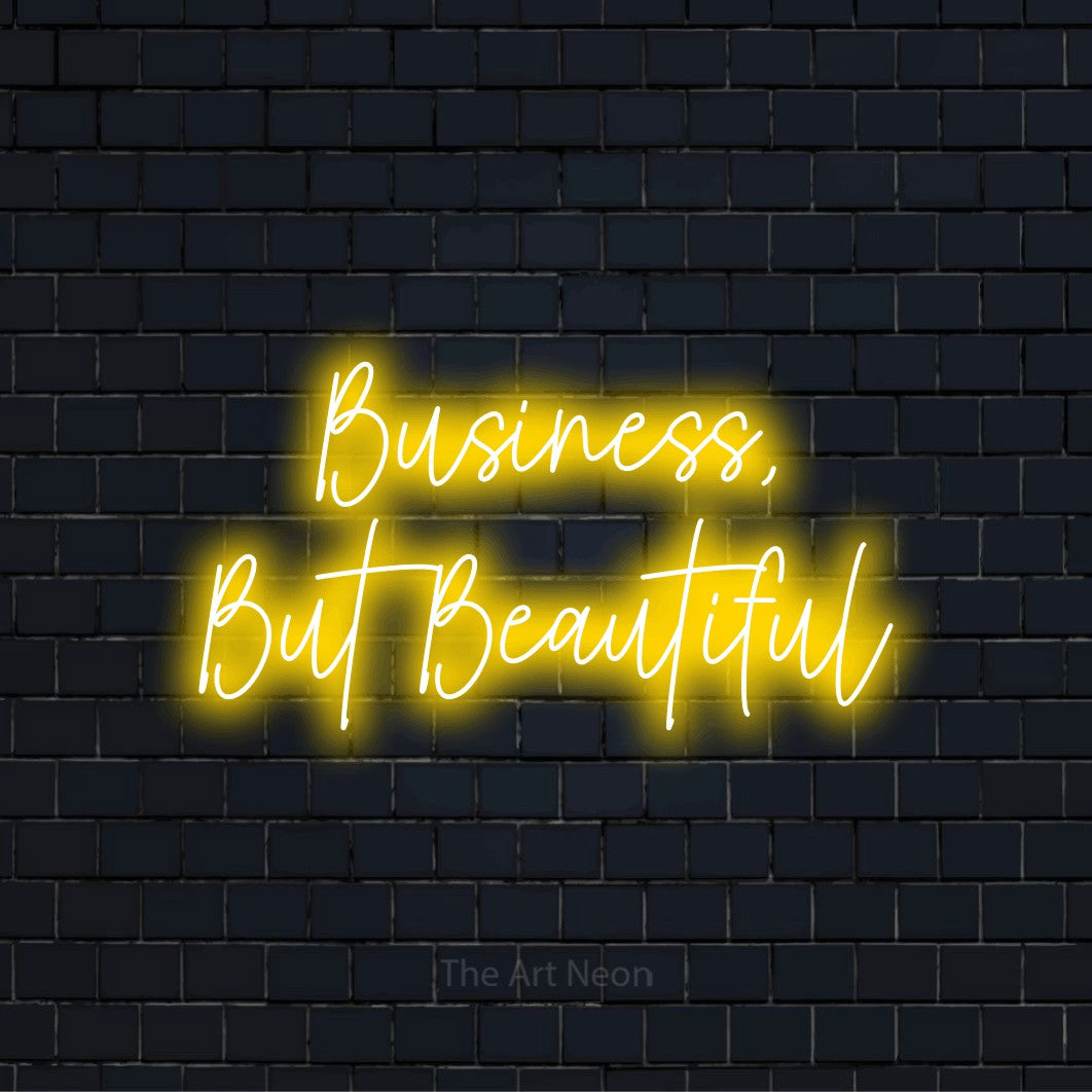 "Business, But Beautiful" glowing LED neon sign on a black brick wall