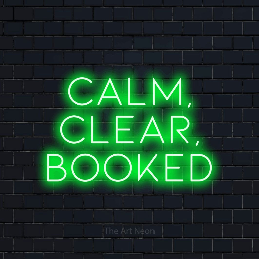 "Calm, Clear, Booked" glowing LED neon sign on a black brick wall