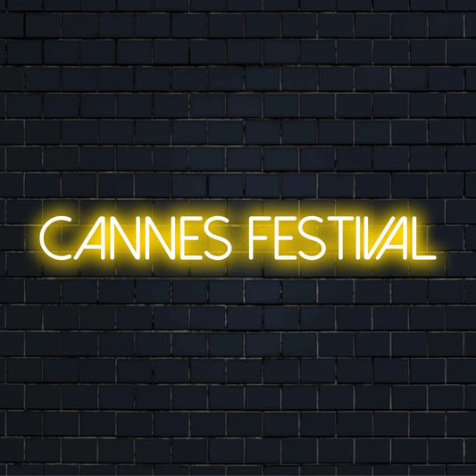 Cannes Festival Neon Light with glowing lettering on dark brick wall
